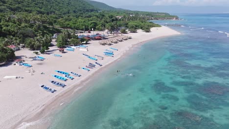 Luftaufnahme-Des-Quemaito-Strandes-Mit-Booten-Und-Schwimmenden-Touristen-Im-Klaren-Wasserufer-Von-Barahona,-Dominikanische-Republik