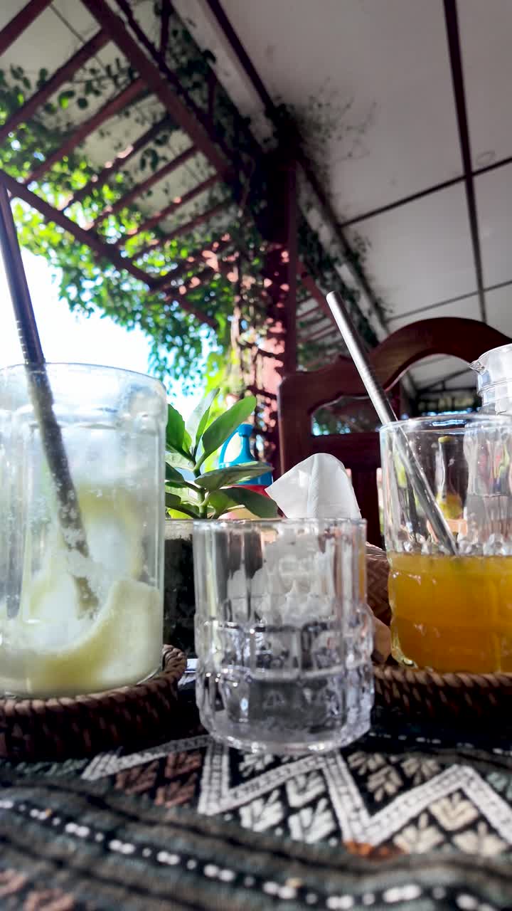 Empty drink glasses with straws are seen on a table in a in Vang Vieng Laos Southeast Asia a popular travel and tourism vacation destination with an outdoor setting