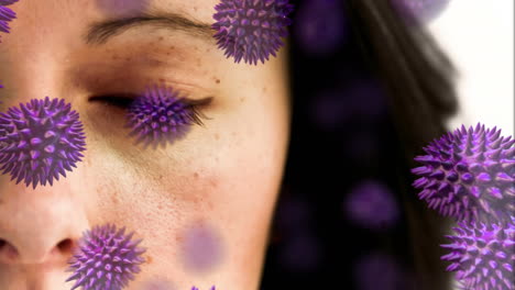 animación de una mujer caucásica abriendo los ojos sobre macros células de covid-19 flotando.