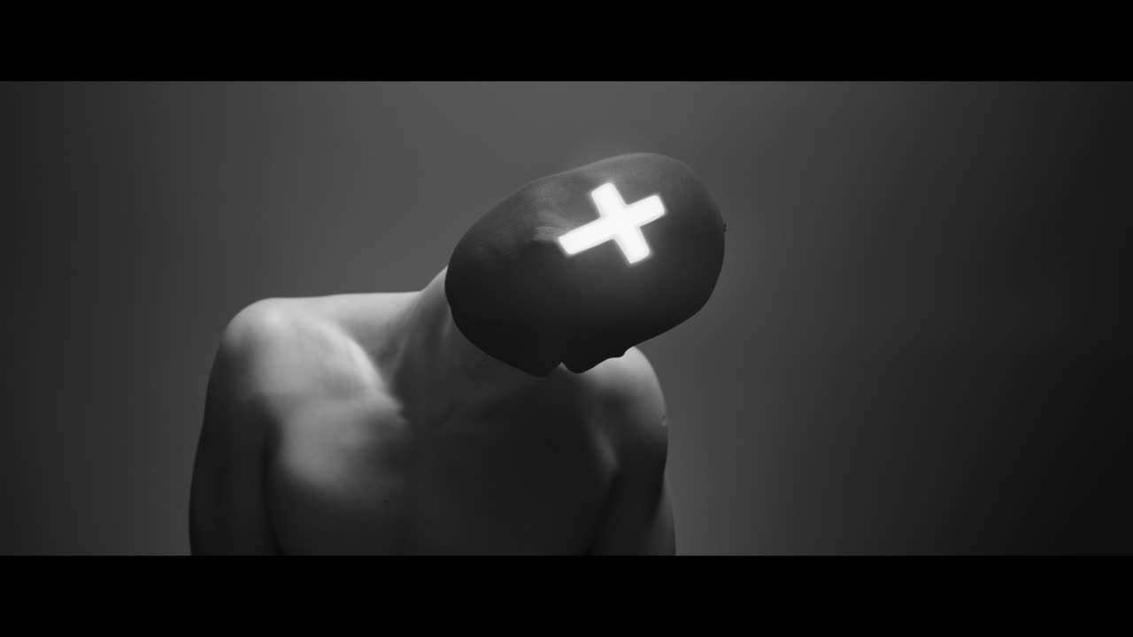 Masked man with cross of light glowing on his face moves slowly