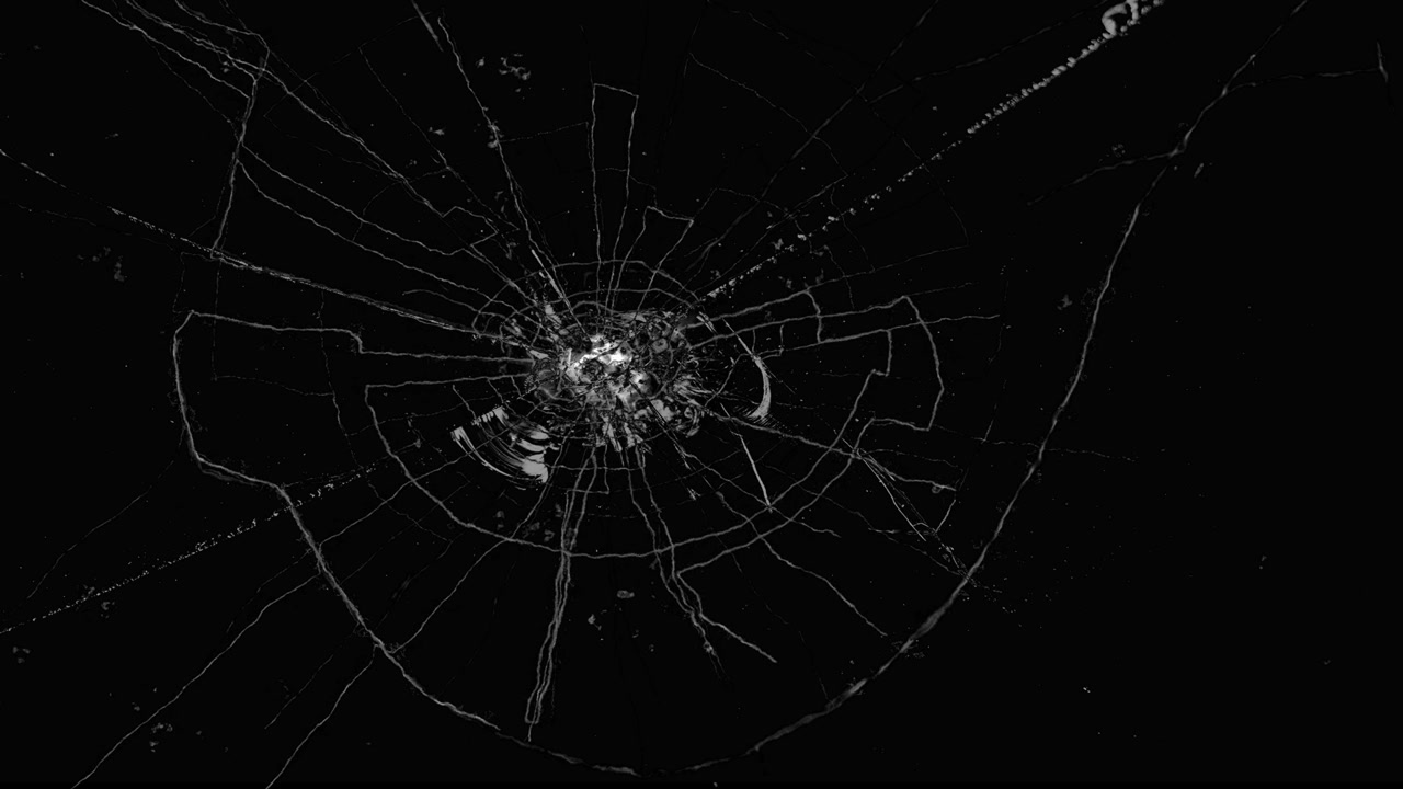 Effetto vetro frantumato circolare o schermo incrinato che si origina dal centro su sfondo nero.