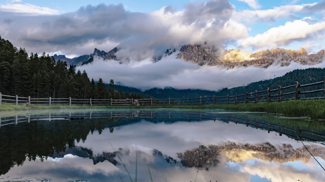 Lago Santner Pass Refletindo Claramente Montanhas, Nuvens e Árvores sob um Céu Azul. Timelapse