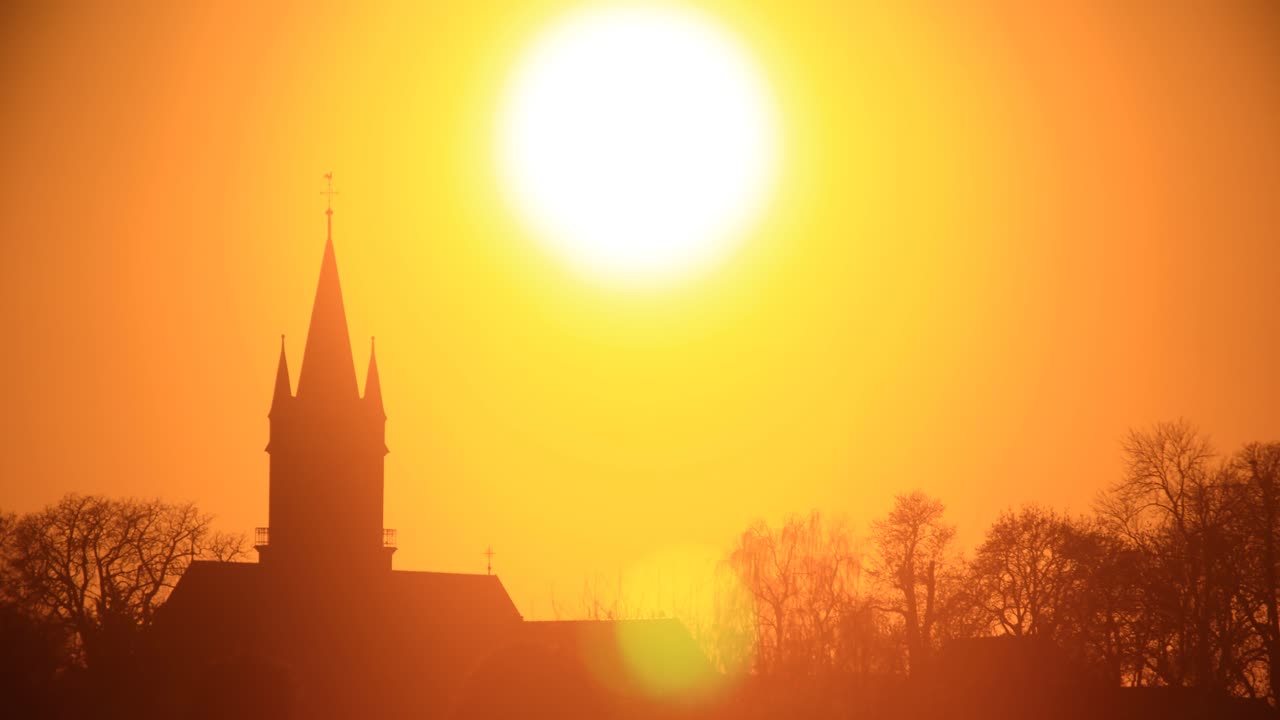 lapso de tiempo de puesta de sol naranja sobre la silueta de la iglesia en magdeburgo, alemania