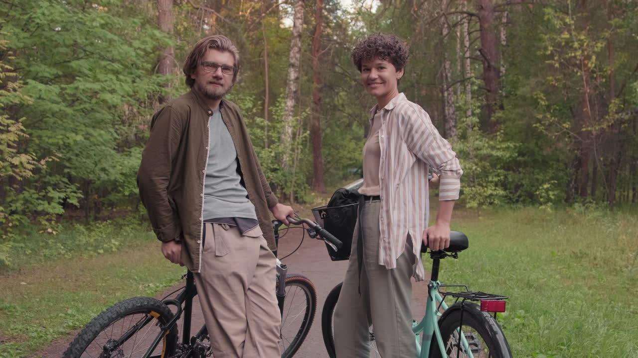 Portrait Of Sporty Couple With Bikes In Woods