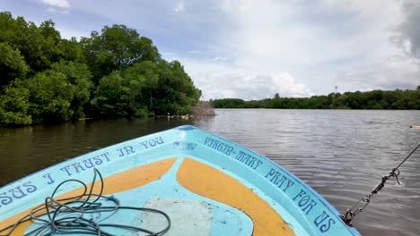 a boat sailing through negombo lagoon with a view of a small forested island, capturing a serene and peaceful landscape scene.