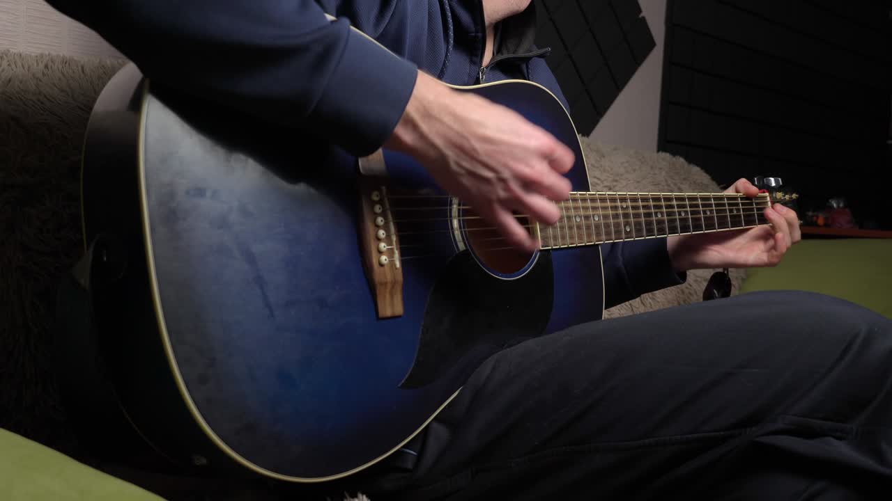 hombre toca una pica en una guitarra moderna en la oscuridad