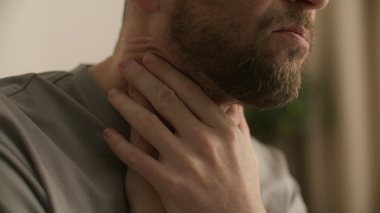 Primo piano di un uomo che si tocca la gola per il dolore