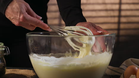 static shot of woman's hands whipping cream in a bowl for a tiramisu, interior