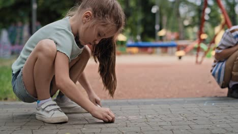 group of caucasian girl coloring with chalk in summer day.