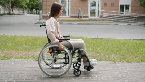 woman in wheelchair on city sidewalk