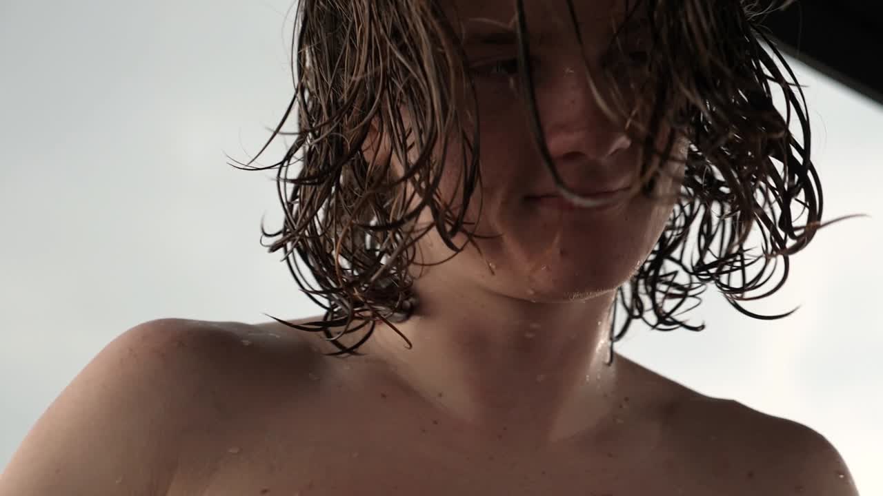 새로 물 밖으로 나온 남자가 배 위에 서 있습니다.