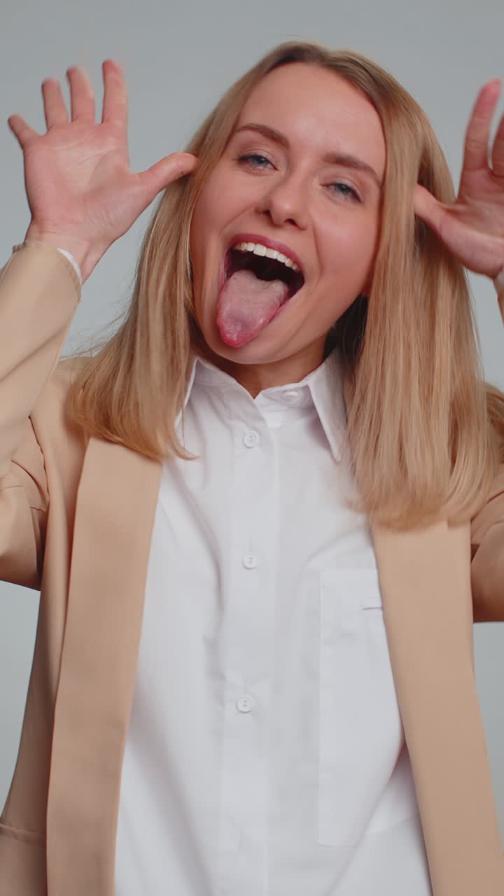 Allegra e divertente donna d'affari che mostra la lingua, fa facce buffe, scherza e si prende gioco