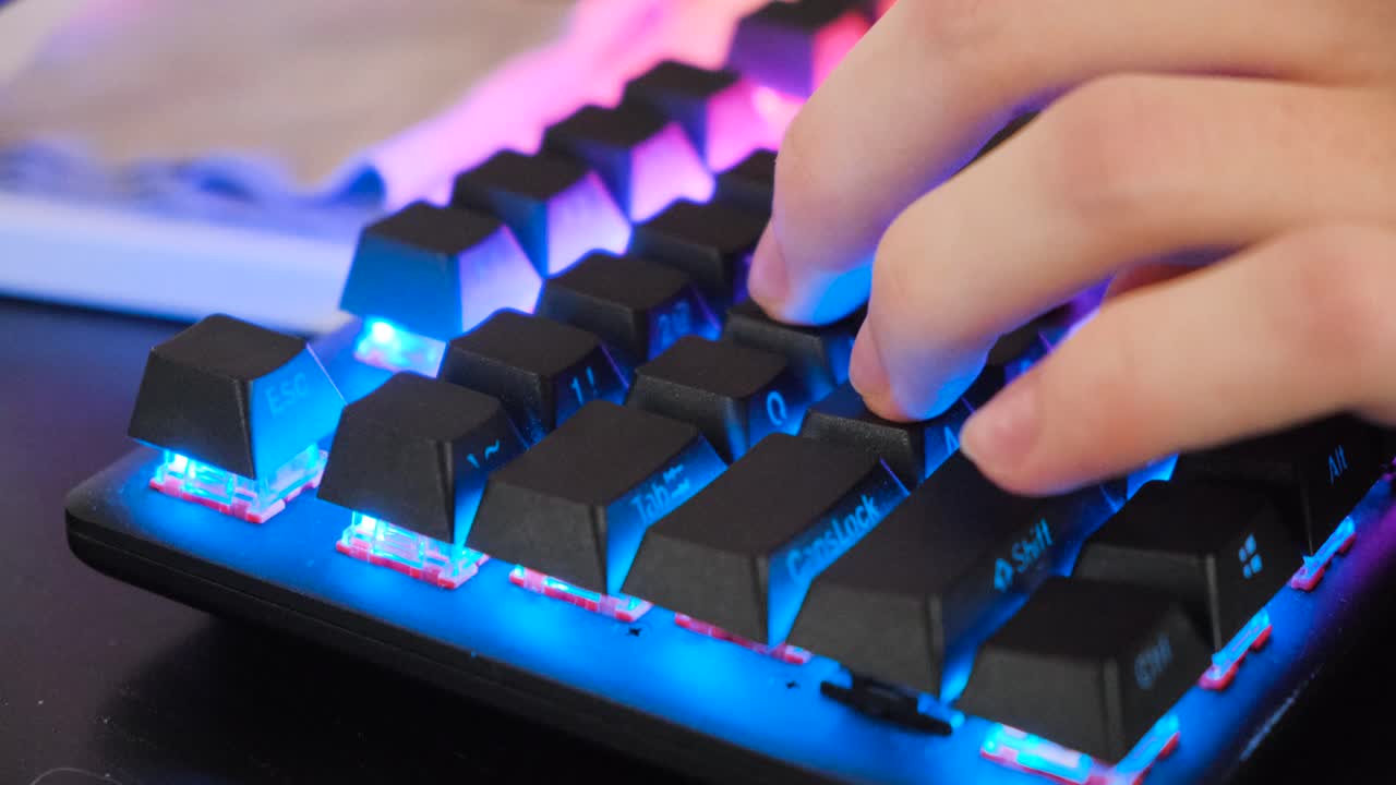 primo piano di mani che scrivono su una tastiera da gioco rgb