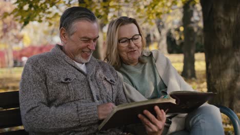 senior caucasian couple looking at old photo album.