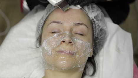 cosmetologist make ultrasonic face cleaning on woman face in beauty clinic salon