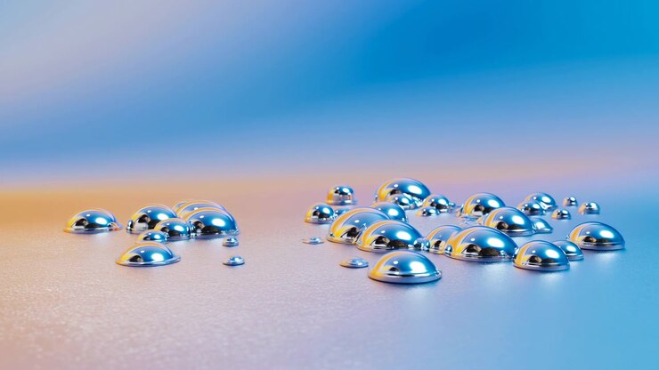 Clustered glossy droplets rest on finely textured surface under soft diffuse lighting, creating bright reflections, subtle pastel color shifts, smooth depth, and elegant minimalist visual rhythm