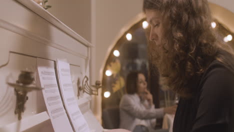 Curly-Woman-Playing-Piano-At-Restaurant-1