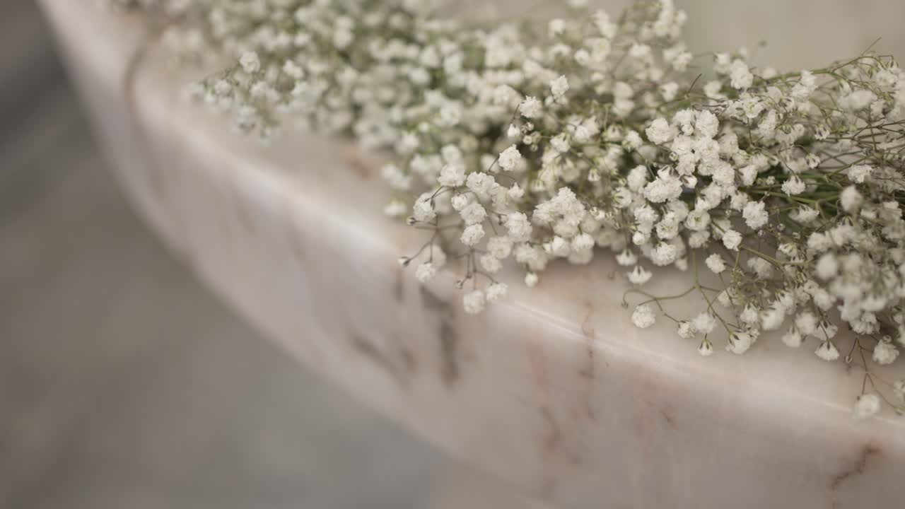 Close view of white gypsophila flowers on marble baptismal font