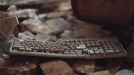 old computer keyboard in an abandoned building is among the garbage