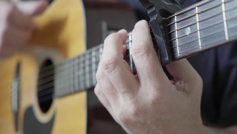 un guitarrista tocando fingerstyle en una guitarra acústica