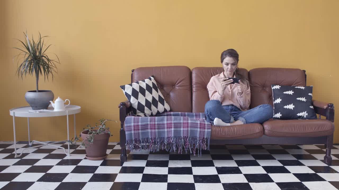 소파에서 휴식을 취하고 전화를 하는 여자