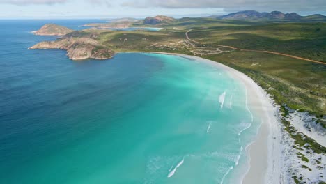 Vista-Aérea-De-Un-Automóvil-4x4-Conduciendo-En-La-Playa,-Olas---Lucky-Bay,-Australia---Plataforma-Rodante,-Disparo-De-Drone