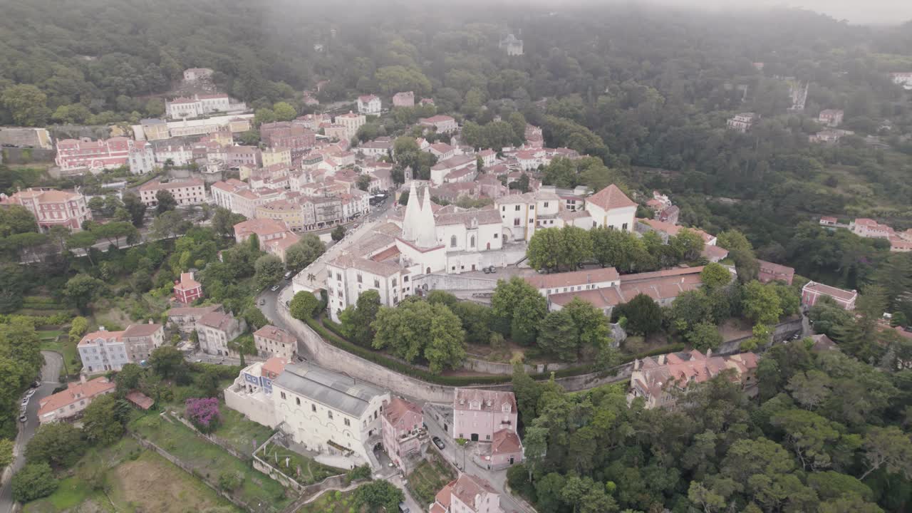 toma aérea cinematográfica en órbita que captura el palacio de la ciudad residencial de sintra en un clima nublado