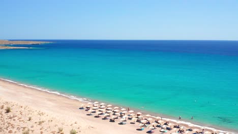 Unrecognizable-people-enjoying-umbrellas,-palapas-and-beach-loungers-Paleopoli-Beach,-Kythira