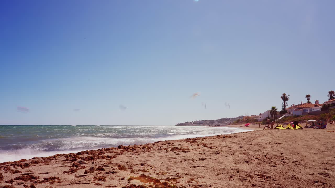 Time-lapse en la playa con varios kitesurfistas en el mar