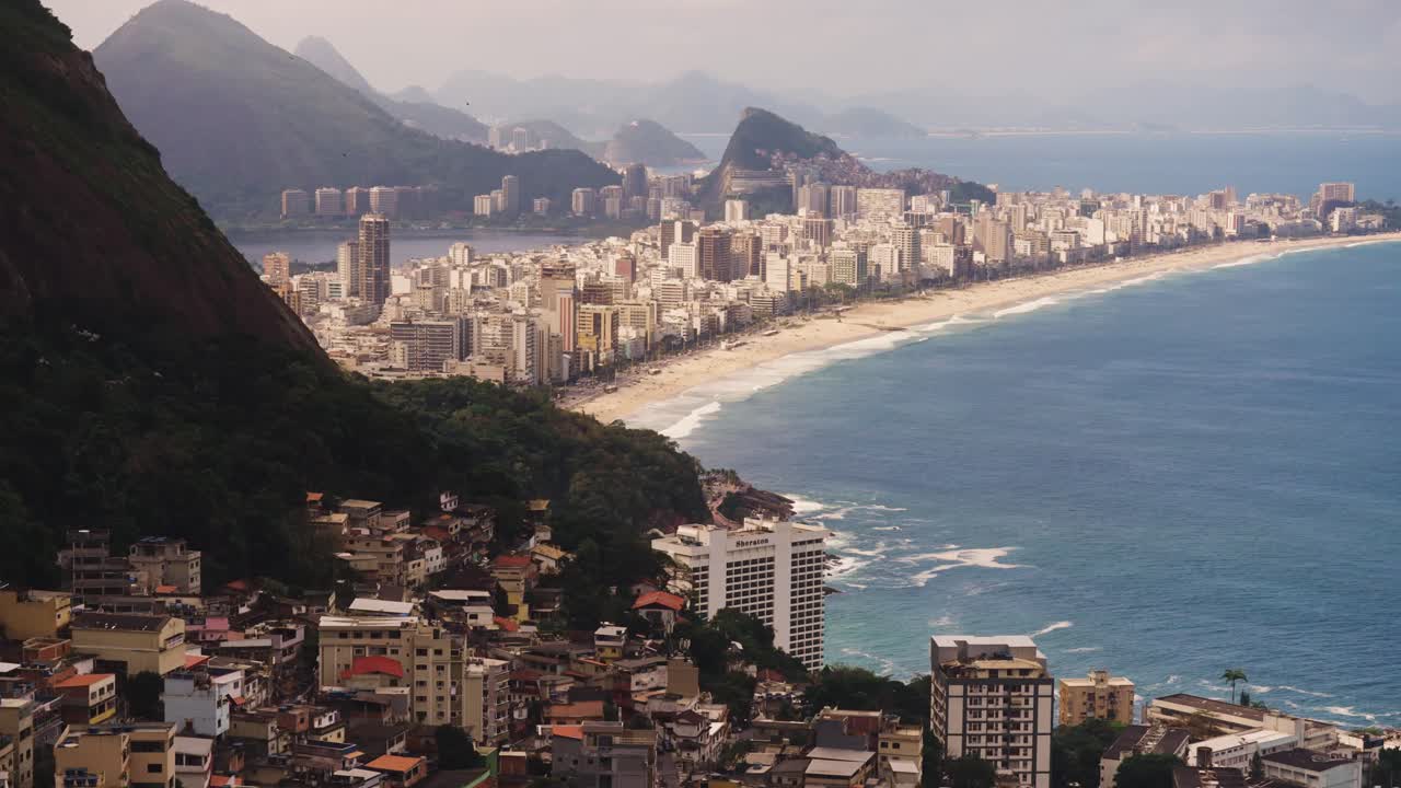 Aerial wide shot showing skyline of Copacabana and Favela in foreground during sunset time in Rio de Janeiro, Brazil