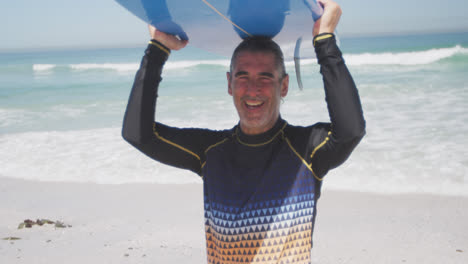 Hombre-Caucásico-Mayor-Sosteniendo-Una-Tabla-De-Surf-En-La-Playa