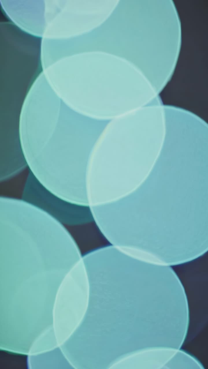 Abstract video background with soft-focus bokeh circles in cool tones
