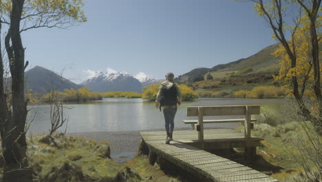 female hiker visiting glenorchy lake lookout in new zealand on sunny day