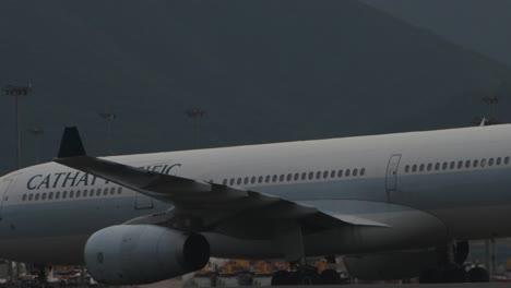 close up of a cathay pacific passenger jet slowly passing by the control tower at the airport