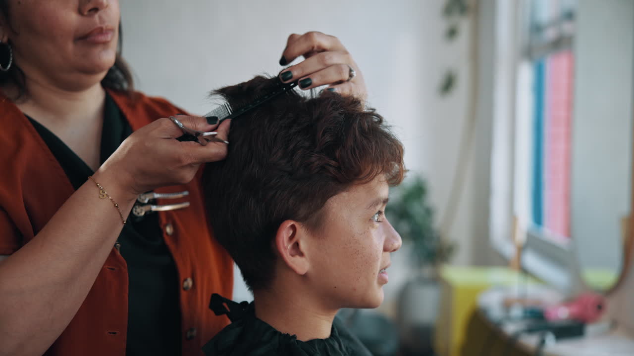 Primo piano di un barbiere che taglia i capelli a un giovane cliente