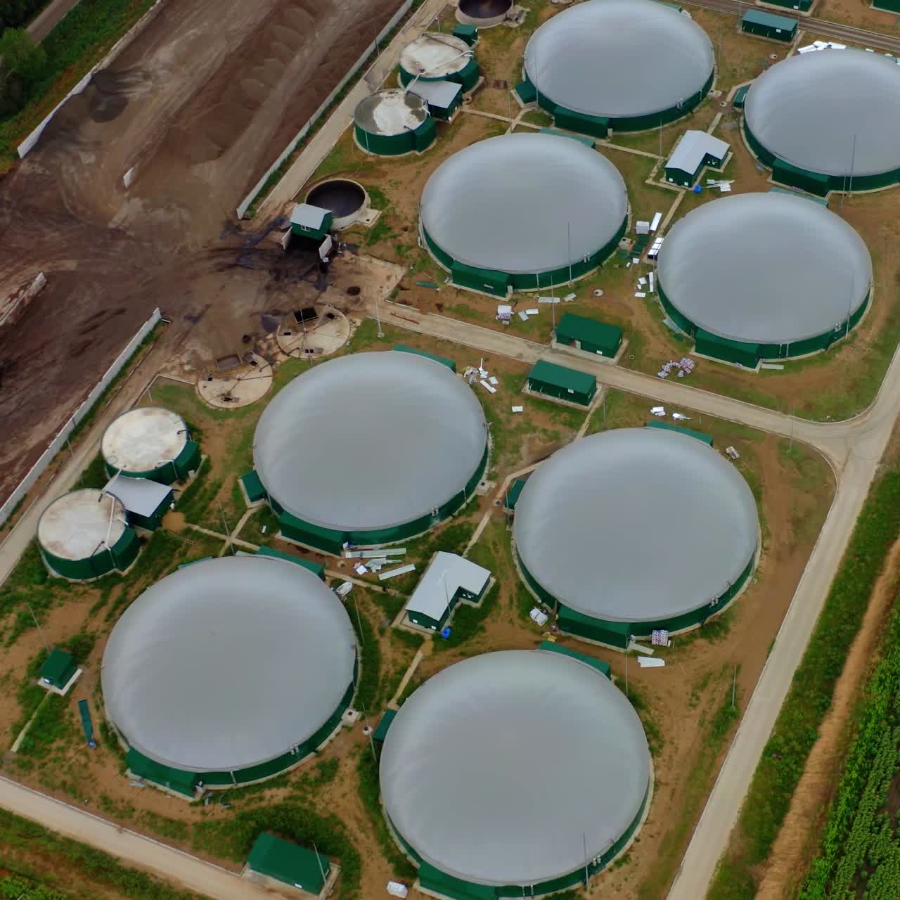 Round roofs of bio gas station. View from above. Video. Factory out of town. Modern plant. Ecological production.
