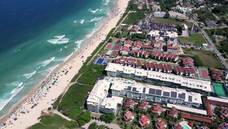 Aerial drone view of buildings and houses on the seafront, colorful roofs with modern architecture and urban planning in Brava Beach, Florianopolis. Luxury beach houses, urban planning on the coast