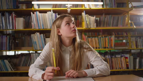 chica adolescente aprender en la biblioteca, pensando en una tarea escolar, tiro de mano