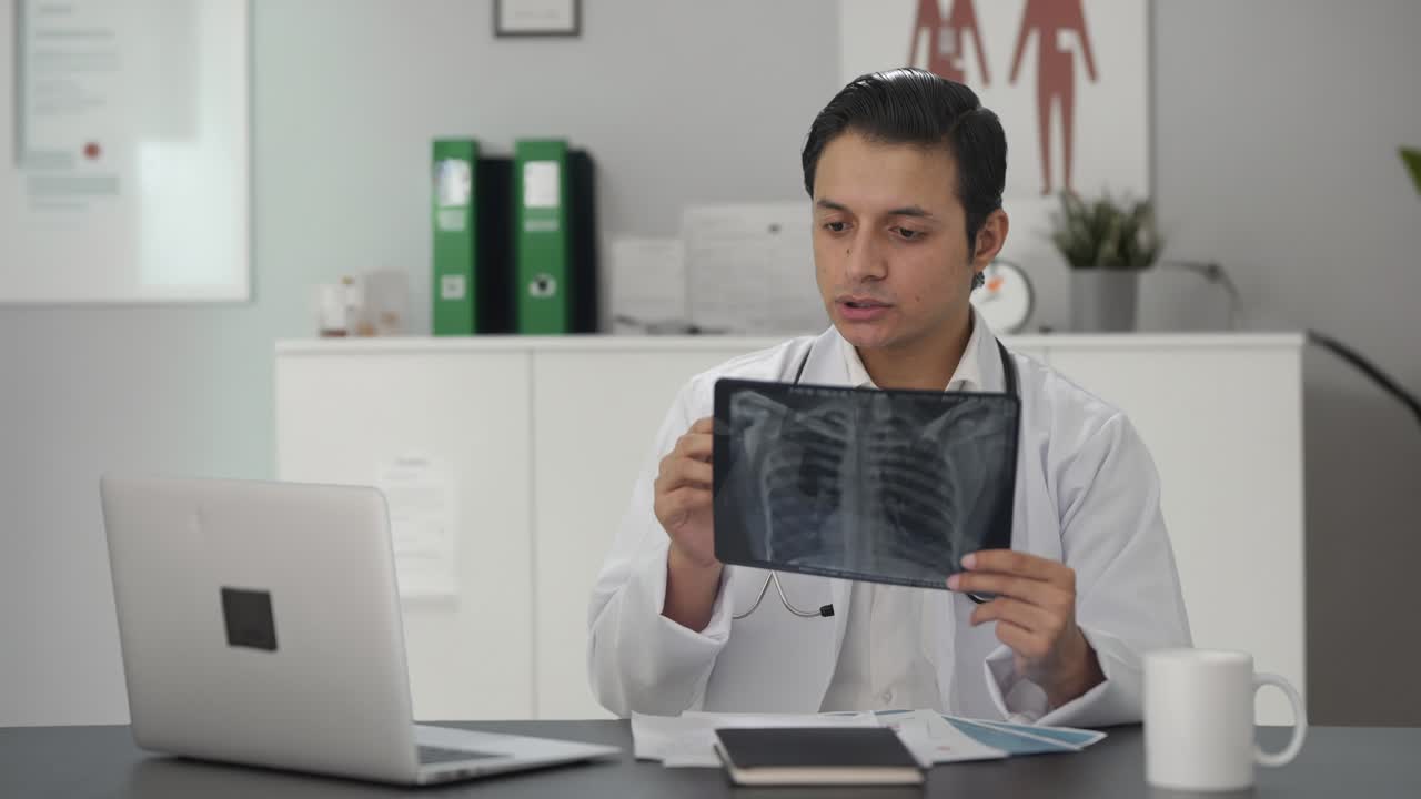 el médico indio chequeando el informe de rayos x.