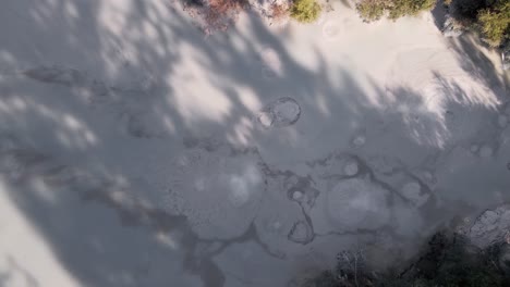 Top-down-aerial-view-of-excessively-gushing-mud-pools-in-a-thermally-active-region-of-New-Zealand