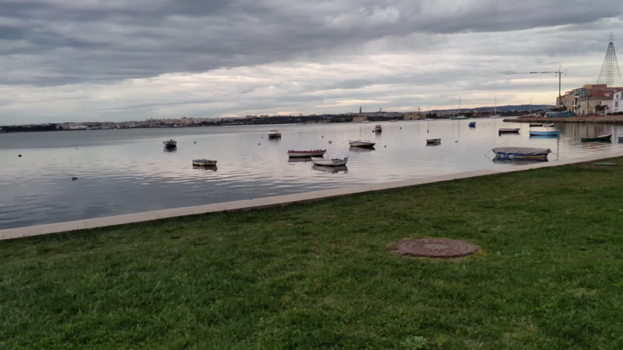 흐린 날 잔잔한 강에 정박해 있는 보트를 타고 강둑 옆 잔디밭을 걷다 - 슬로우 모션