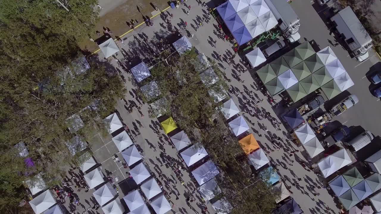 video aéreo de drones de 4k del mercado de agricultores en el estacionamiento del estadio de fútbol frente al mar en st