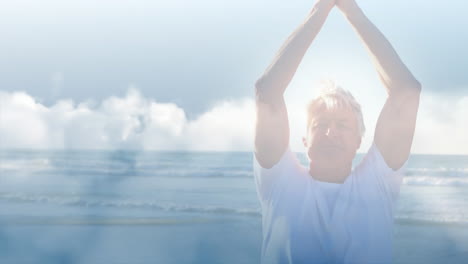 animation of glowing light over happy senior man practicing yoga by seaside