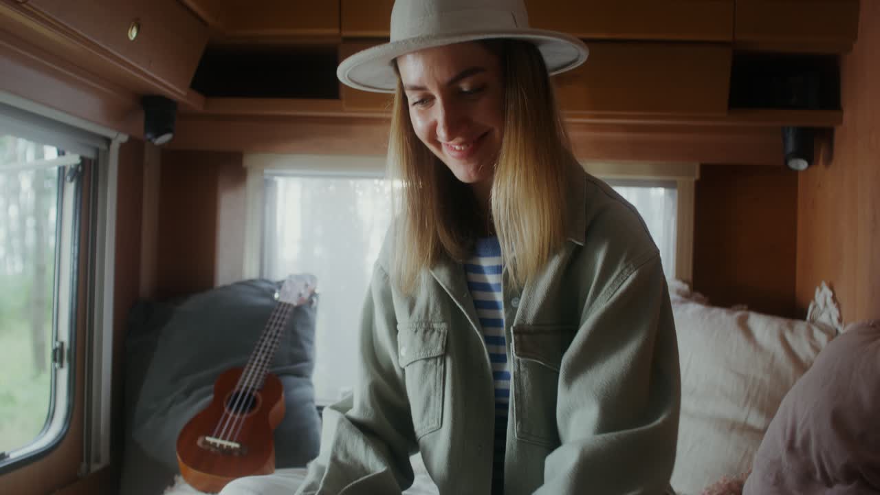 노트북 과 우쿨레 를 들고 캠퍼 밴 에서 휴식을 취 하는 여자