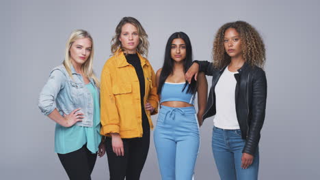 studio shot of young independent multi-cultural female friends looking into camera in slow motion