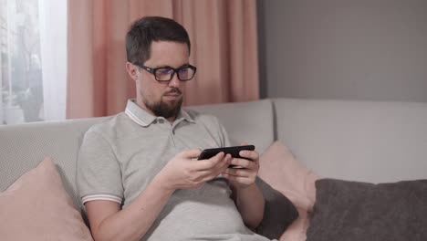 man using a smartphone on a couch