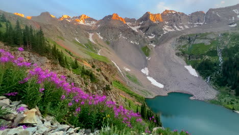 Cinematic-aerial-drone-alpine-sunset-at-Blue-Lakes-Colorado-Mount-Sniffels-Dallas-Peaks-Wilderness-snow-14er-peak-purple-wildflowers-Ridgway-Telluride-Ouray-Silverton-hike-slow-pan-to-the-right