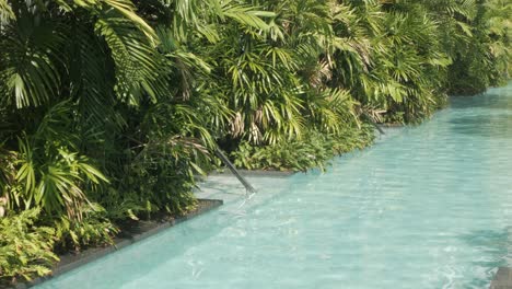 La-Superficie-Del-Agua-De-La-Piscina-Se-Refleja-En-Un-Día-Soleado,-El-Agua-Clara-En-El-Fondo-Del-Complejo-De-Vacaciones-De-Verano