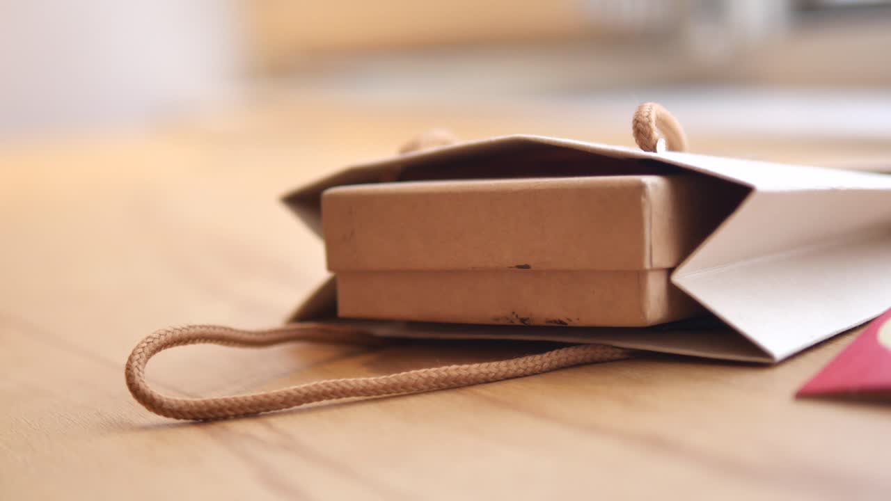 Gift in Shopping Bag on Wooden Table
