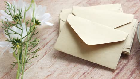 brown envelopes and flowers on a table